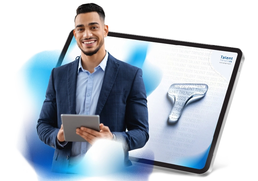 A smiling man with a tablet in his hands stands in front of an image of a tablet displaying the front page of Talent Trends.