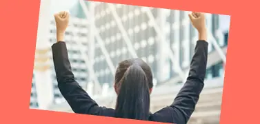 Une femme en tenue de bureau avec les mains levées.