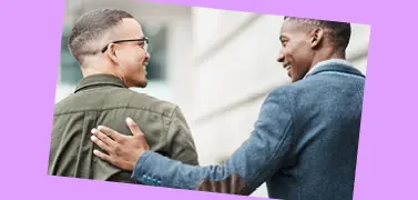 Deux collègues de races différentes souriant ensemble.