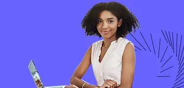 A woman in an office attire sitting in front of a laptop.