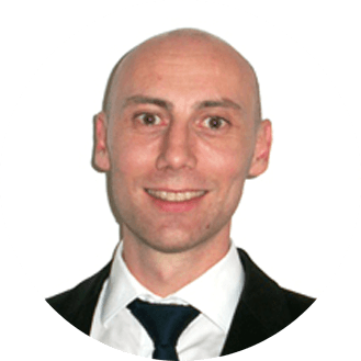 Person smiling in formal attire with a white background.