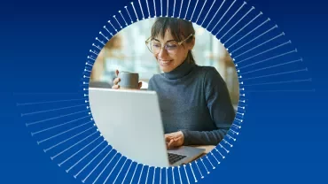 Person smiling while using a laptop, holding a cup, with a blue halo background.