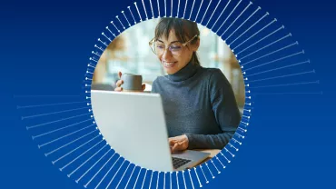 Person smiling while using a laptop, holding a cup, with a blue halo background.