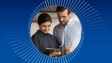 Two people looking at a tablet, surrounded by a circular graphic.
