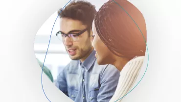 Two people collaborating and smiling in an office setting.