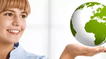 Person smiling with a globe hovering above their hand.