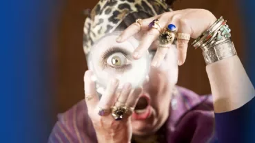 Person holding magnifying glass with playful expression.