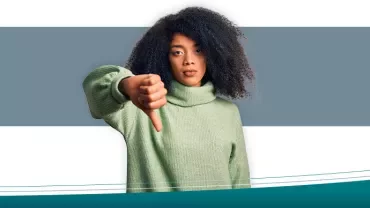 Person in a green sweater giving thumbs down