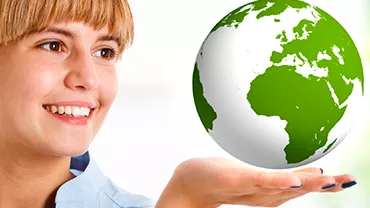 Person smiling, holding a green and white globe in hand.