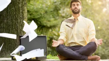 Personne méditant en plein air tandis que des papiers volent d'une mallette.