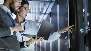 Deux personnes analysant des données de serveur avec un ordinateur portable.