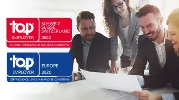 Groep mensen die glimlachen en een document bespreken in een kantoor.