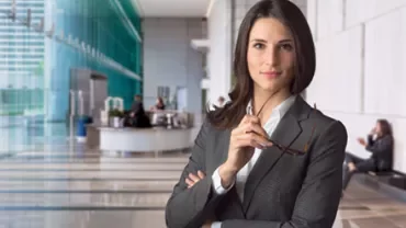 Person in formal attire in a modern office lobby.