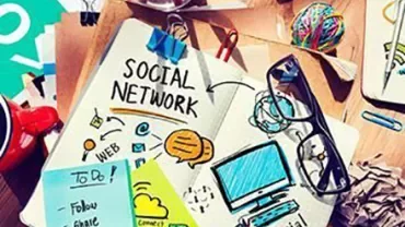 Desk with notebook titled 'Social Network' surrounded by notes and office supplies.