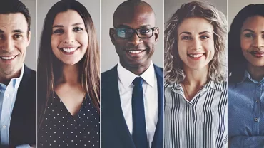 Five people smiling in a professional setting.
