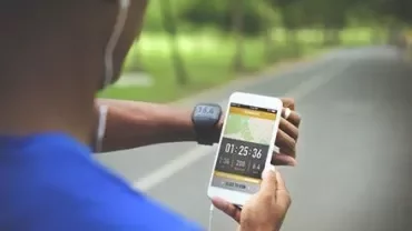 Personne courant et regardant un tracker de fitness sur smartphone.