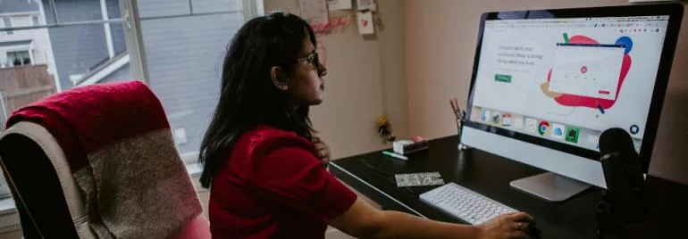 Person seated at desk using a computer.
