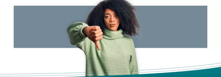 Person in a green sweater giving thumbs down