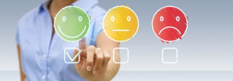 Person selecting a happy face icon on a touchscreen.