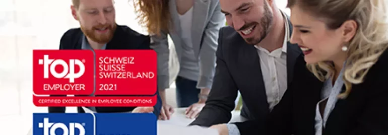 Groupe de professionnels souriants au travail, labels Top Employer affichés.