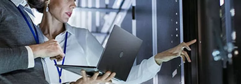 Deux personnes analysant des données de serveur avec un ordinateur portable.