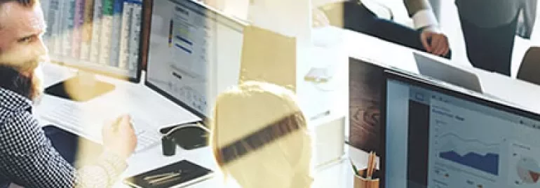 People working at computers in an office environment.