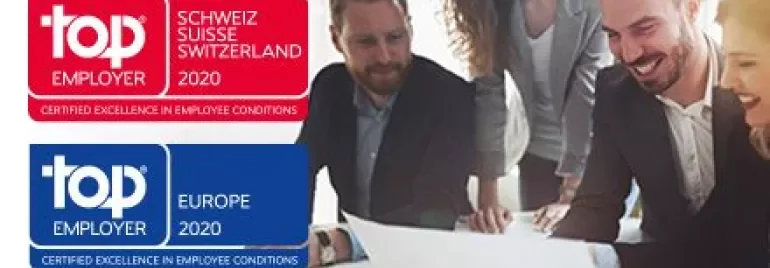 Groep mensen die glimlachen en een document bespreken in een kantoor.