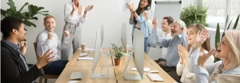 Group of colleagues clapping in a meeting room.