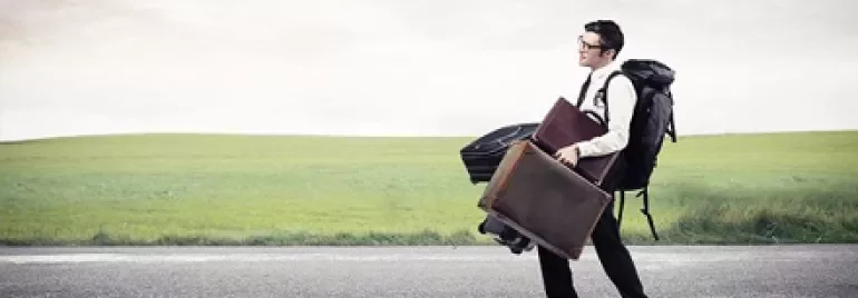Personne marchant sur la route avec plusieurs sacs.