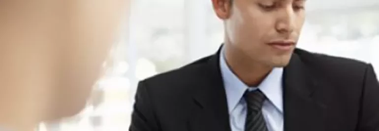 Person in a suit reviewing documents in an office setting.