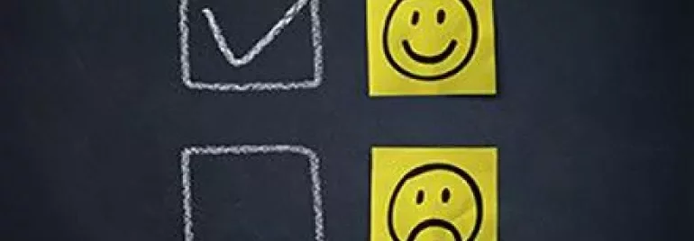 Schoolbord met vinkje en blije gezichten symbolen.