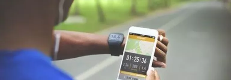 Persoon hardlopen en kijkt naar fitness-tracker op smartphone.