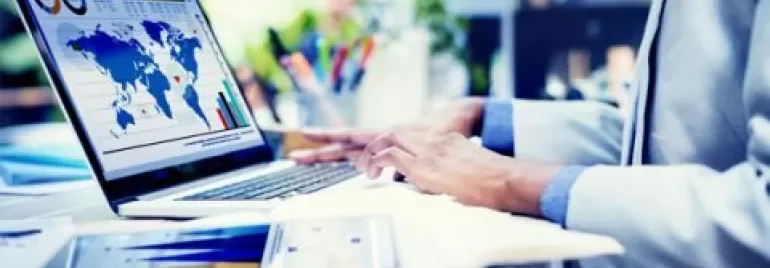 Personne travaillant sur un ordinateur portable avec des graphiques mondiaux.