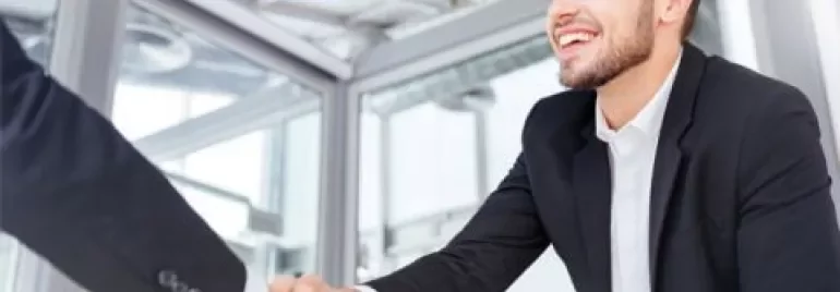 Personne souriante serrant la main dans un bureau.