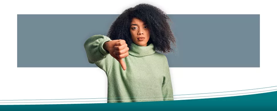 Person in a green sweater giving thumbs down