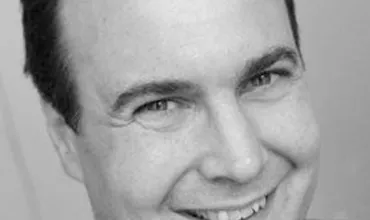 Smiling person in a black and white portrait.