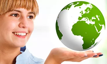 Personne souriante tenant un globe vert et blanc dans la main.