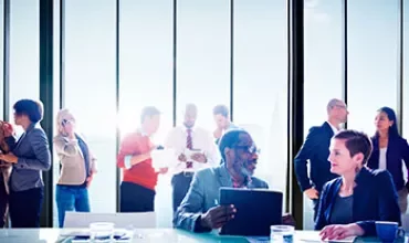 Personnes dans un bureau discutant affaires autour d'une table de conférence.