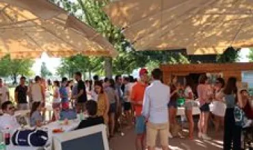 Une réunion en plein air animée sous de grandes tentes avec des gens qui discutent.