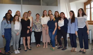 A group of people standing in an office.