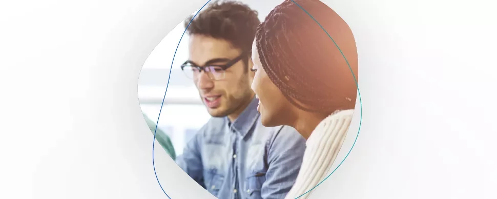 Two people collaborating and smiling in an office setting.
