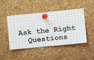 Notecard pinned on corkboard with 'Ask the Right Questions' written on it.