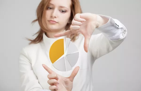 Person framing a floating pie chart with yellow segment.
