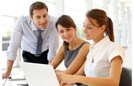 Drie mensen werken samen met een laptop.